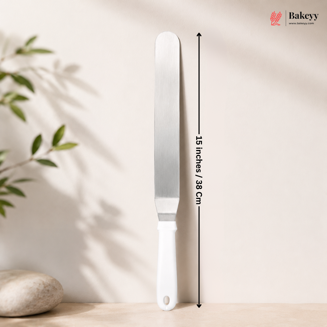 White cake knife with measurement label on a neutral background