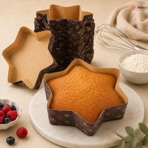 Star-shaped cake in a decorative pan on a marble surface with baking ingredients.