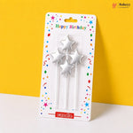 Three silver star-shaped birthday candles in packaging with 'Happy Birthday' text on a yellow background.