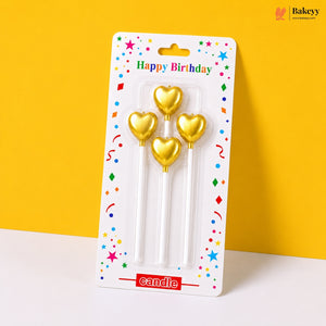 Gold heart-shaped candles in packaging with 'Happy Birthday' text on a yellow background