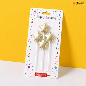 Packaged gold star-shaped birthday candles on a yellow background