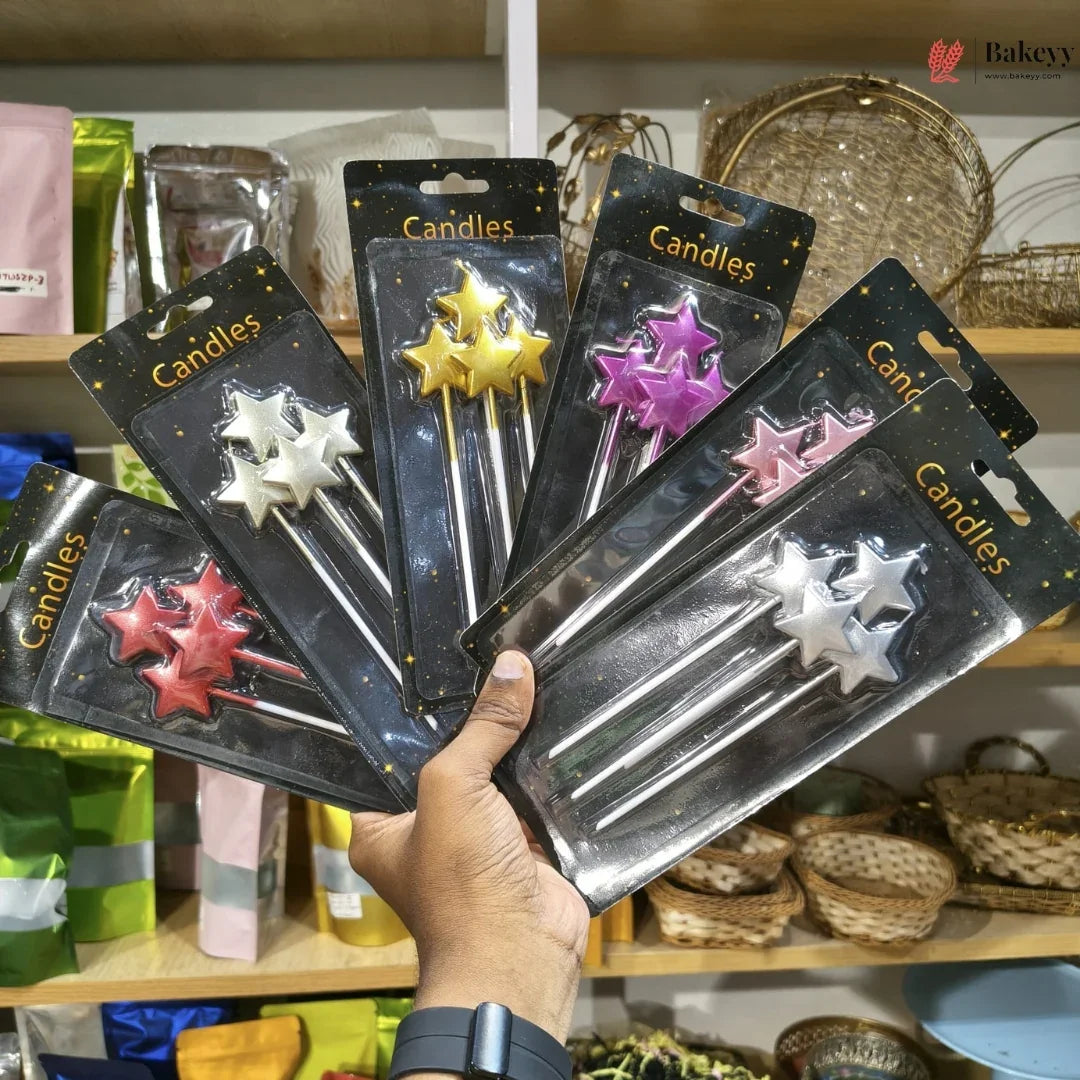 Hand holding packages of star-shaped candles with a store shelf in the background