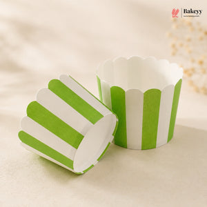 Green and white striped paper cupcake liners on a beige background