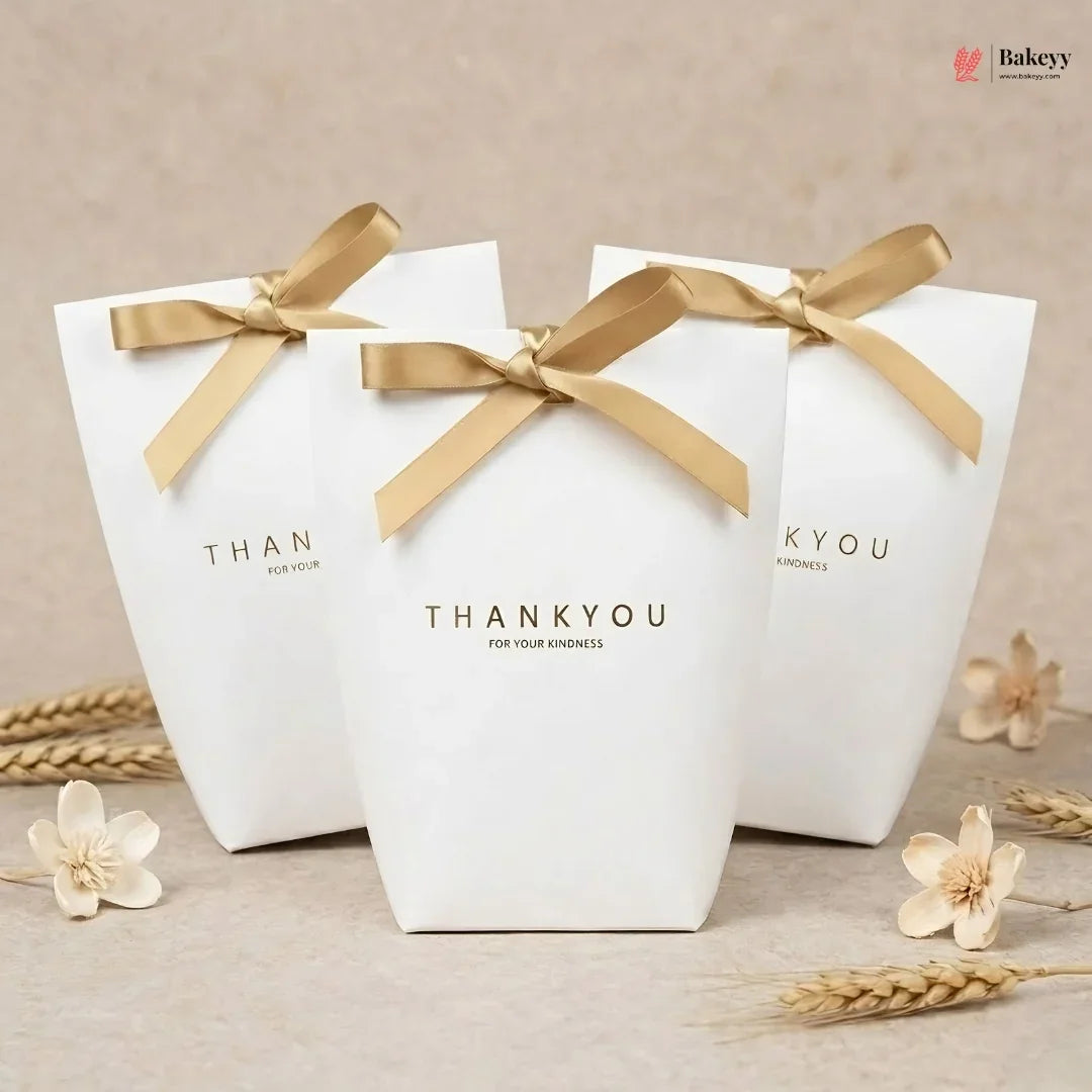 Three white gift boxes with gold ribbons and 'THANKYOU' text on a beige background.