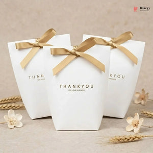Three white gift boxes with gold ribbons and 'THANKYOU' text on a beige background.