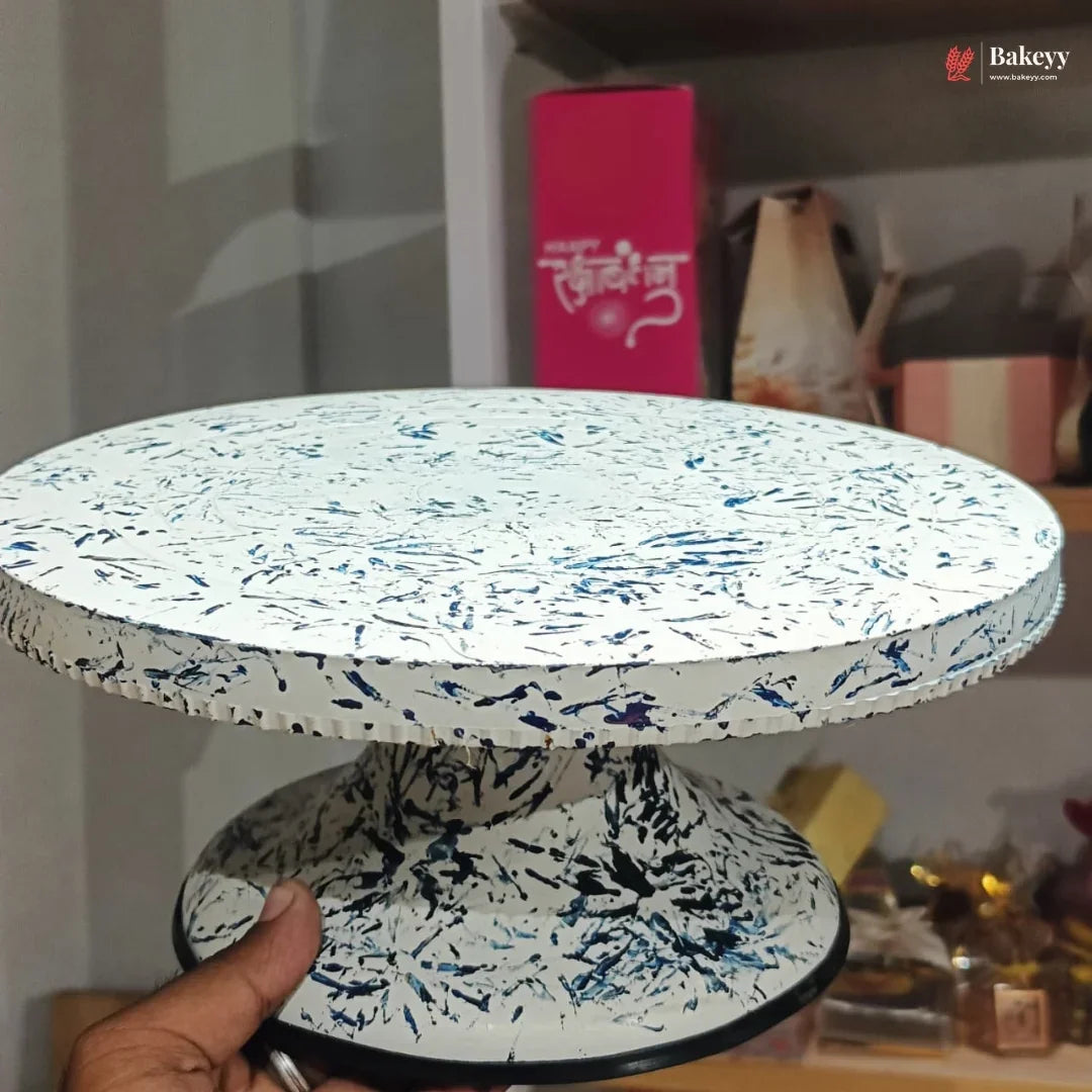 Speckled patterned cake stand held by a hand with a blurred background