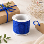 Spool of blue twine with a gift box and decorative elements on a light background