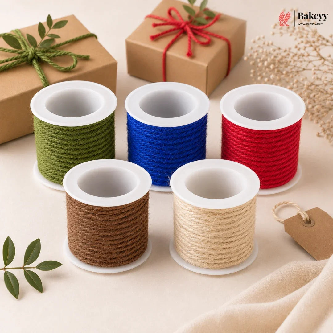Set of spools with green, blue, red, brown, and beige string on a beige background with gift boxes and leaves.