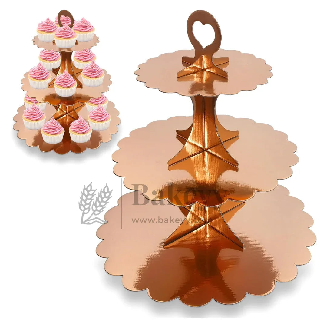 Rose gold three-tiered cupcake stand with pink cupcakes on a white background