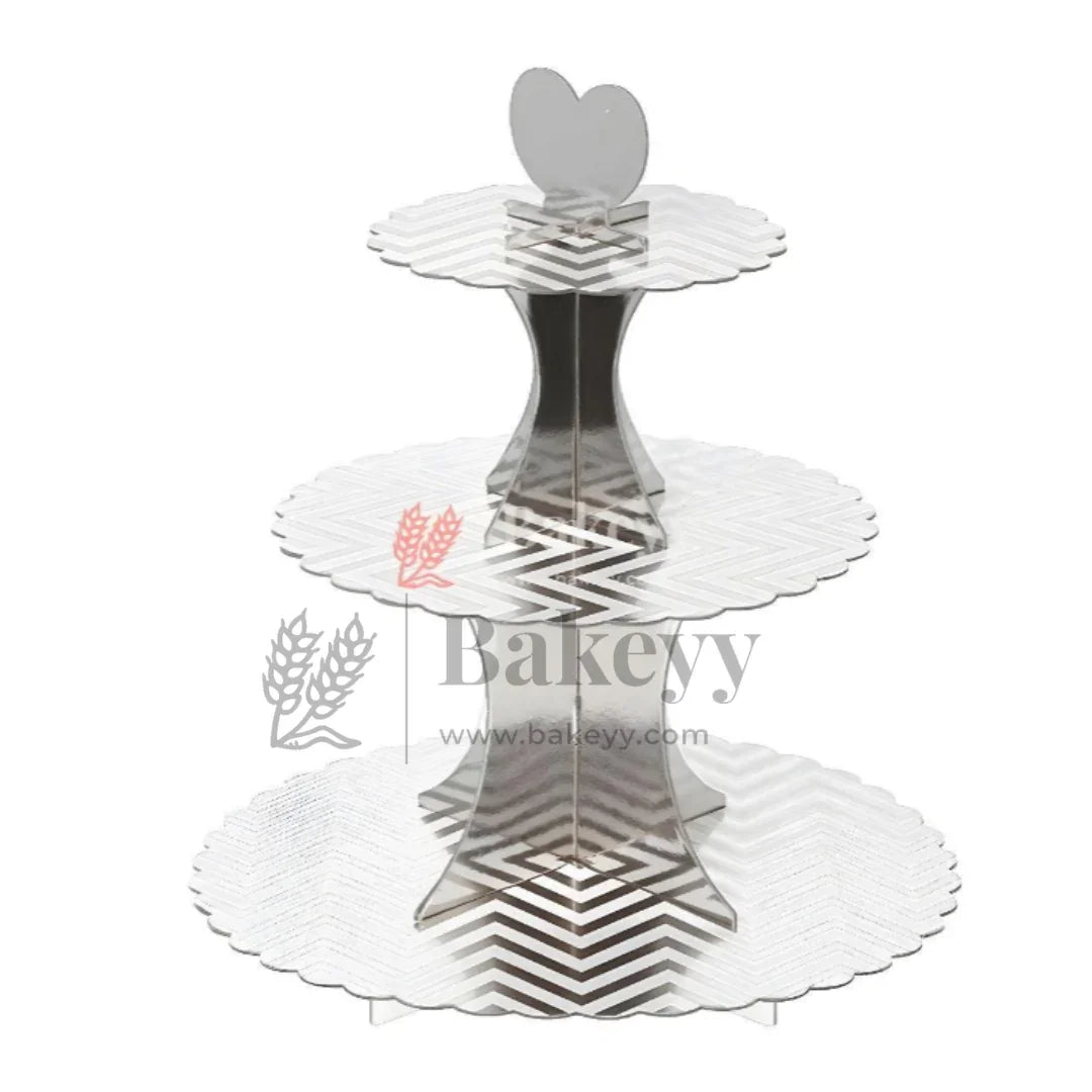 Three-tiered silver cake stand with decorative patterns on a white background, featuring the brand 'Bakevy'.