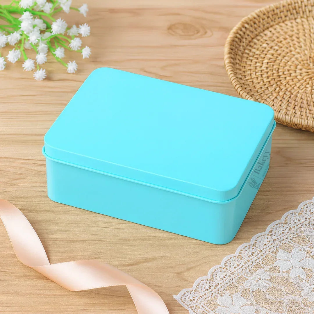 Bakeyy blue tin box for bakery gift packaging on wooden table with ribbon and lace