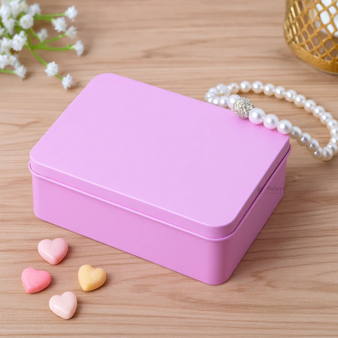 Pink tin gift box on wooden surface with pearl bracelet and heart-shaped candies, Bakeyy packaging