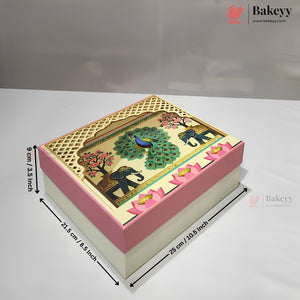 A decorated rectangular cake or gift box with a pink and cream base and a detailed top panel showing a peacock, elephants, and floral motifs. Black dimension arrows and text indicate measurements of 26 cm by 22 cm by 9 cm.