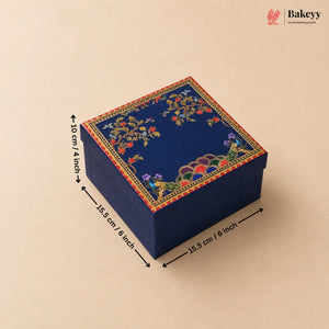 A square navy blue decorative gift box with colorful floral and bird motifs on the lid, shown on a beige background with black dimension arrows and text indicating 15.5 cm by 10 cm by 15.