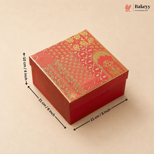 A red square gift box with ornate gold and green patterned detailing on the lid, shown on a beige background with dimension arrows and text indicating measurements of 21 cm by 21 cm by 10 cm.