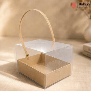 Clear plastic box with a beige paper insert and handle on a beige background, featuring the Bakeyy brand.