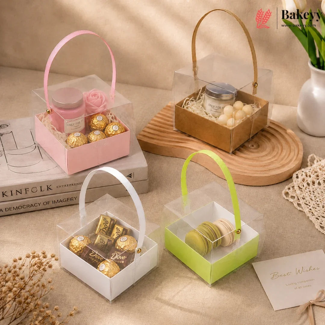 Four transparent gift boxes with handles containing various items on a beige surface.