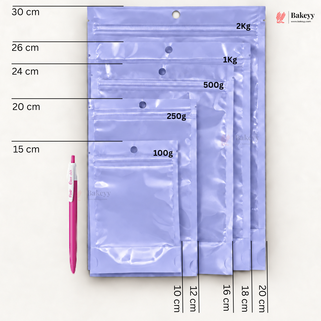 Five lavender plastic zip-top pouches of different sizes arranged vertically on a white background, with printed size measurements in centimeters and weight labels (100g, 250g, 500g, 1kg, 2kg) pointing to each pouch. A pink pen is shown to the left for scale, and the Bakecy logo appears in the top right corner.