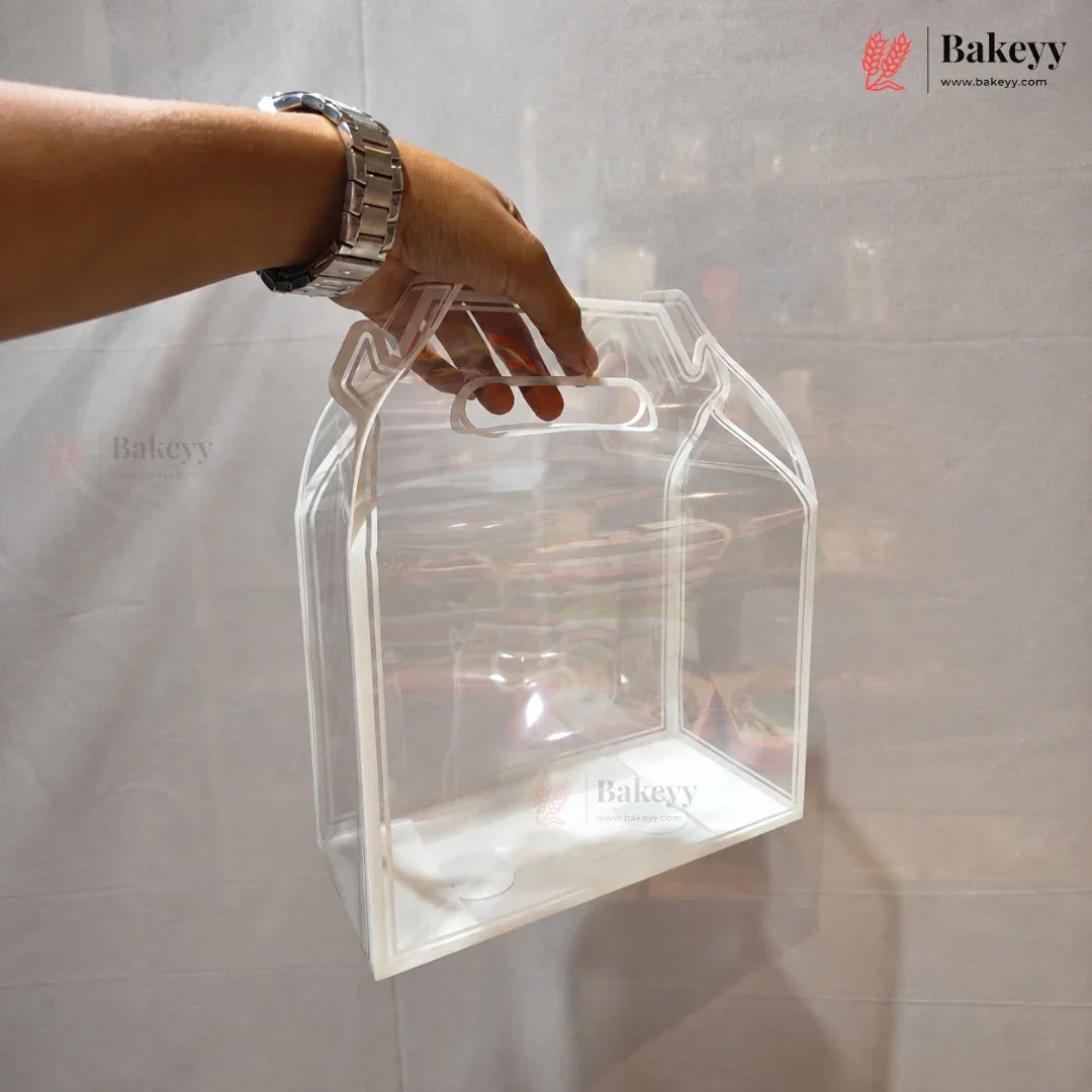 A clear plastic storage box with integrated handles, held by a person's hand against a light gray fabric backdrop.