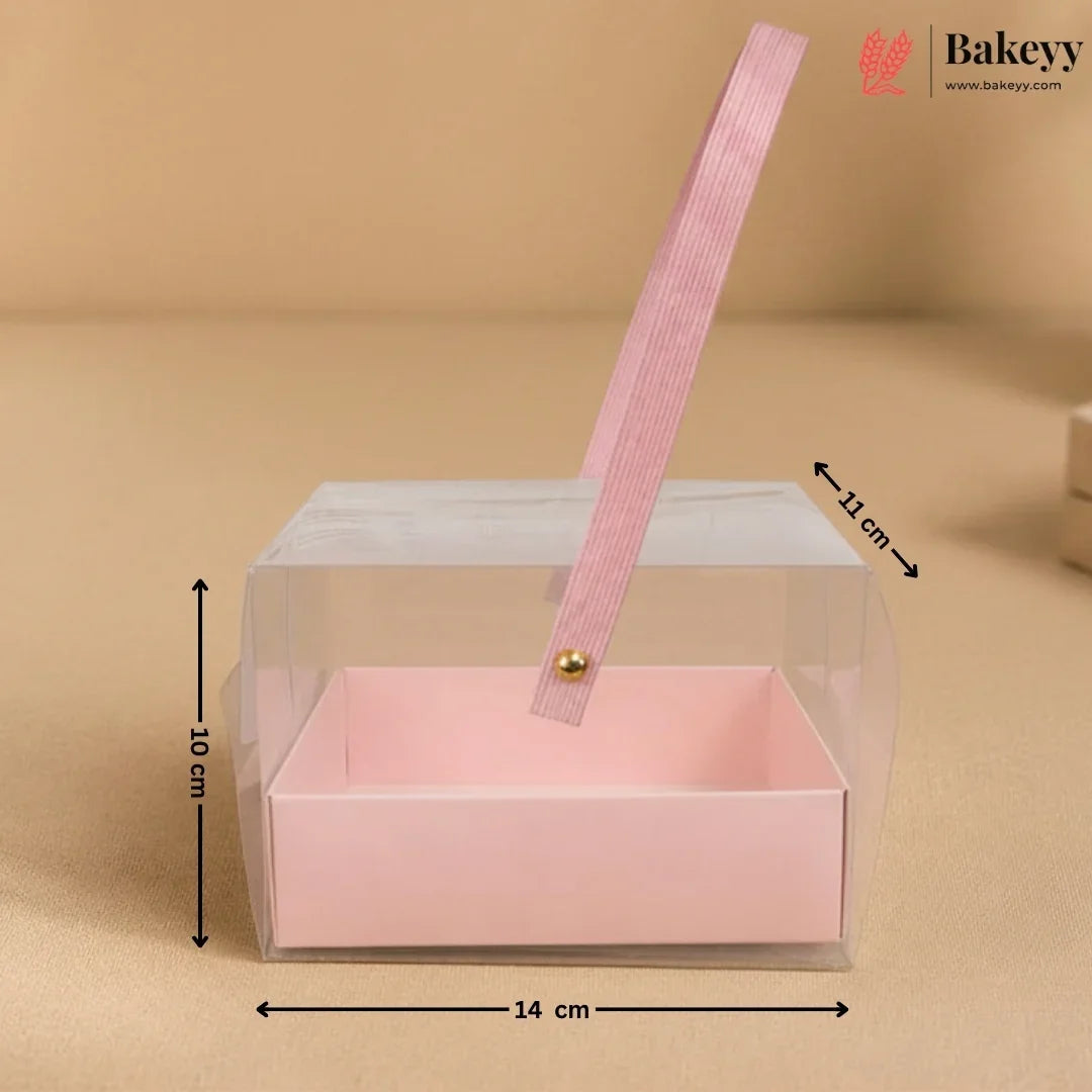 Clear gift box with pink interior and handle, dimensions indicated, on a beige background.