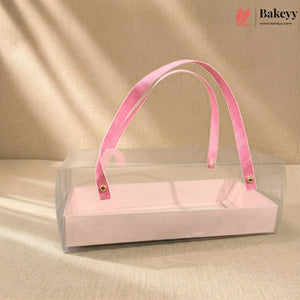 Clear box with pink velvet handle on a beige background, featuring the Bakeyy brand.