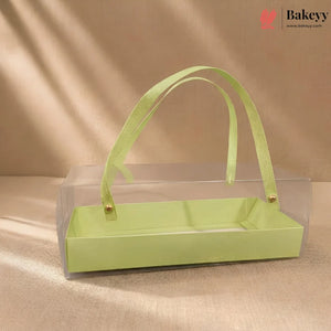 Green rectangular box with a ribbon handle on a beige background, featuring the Bakeyy brand.