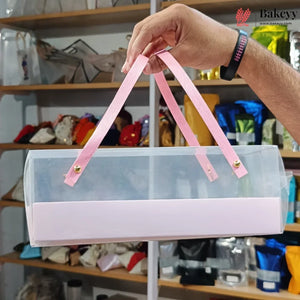 Clear plastic bag with pink handles held by a hand in a store setting