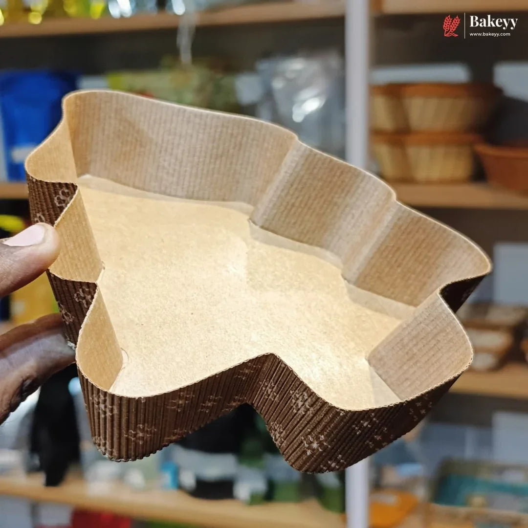 Hand holding a textured brown and beige bowl with a blurred background of shelves.