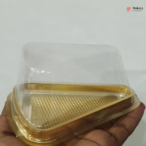 Clear plastic container with gold base held by a hand against a white background