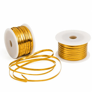 Two spools of gold wire on a white background