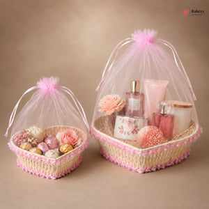 Two decorative baskets with pink tulle, flowers, and small items on a beige background.