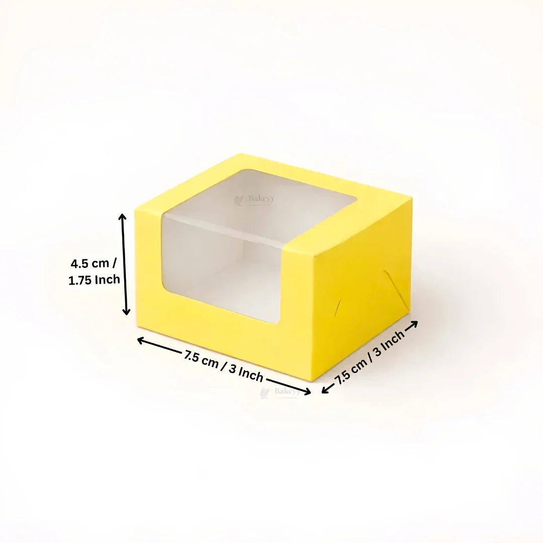 Yellow square box with a clear plastic window on top, shown with dimension arrows and text indicating measurements of 7.5 cm by 7.