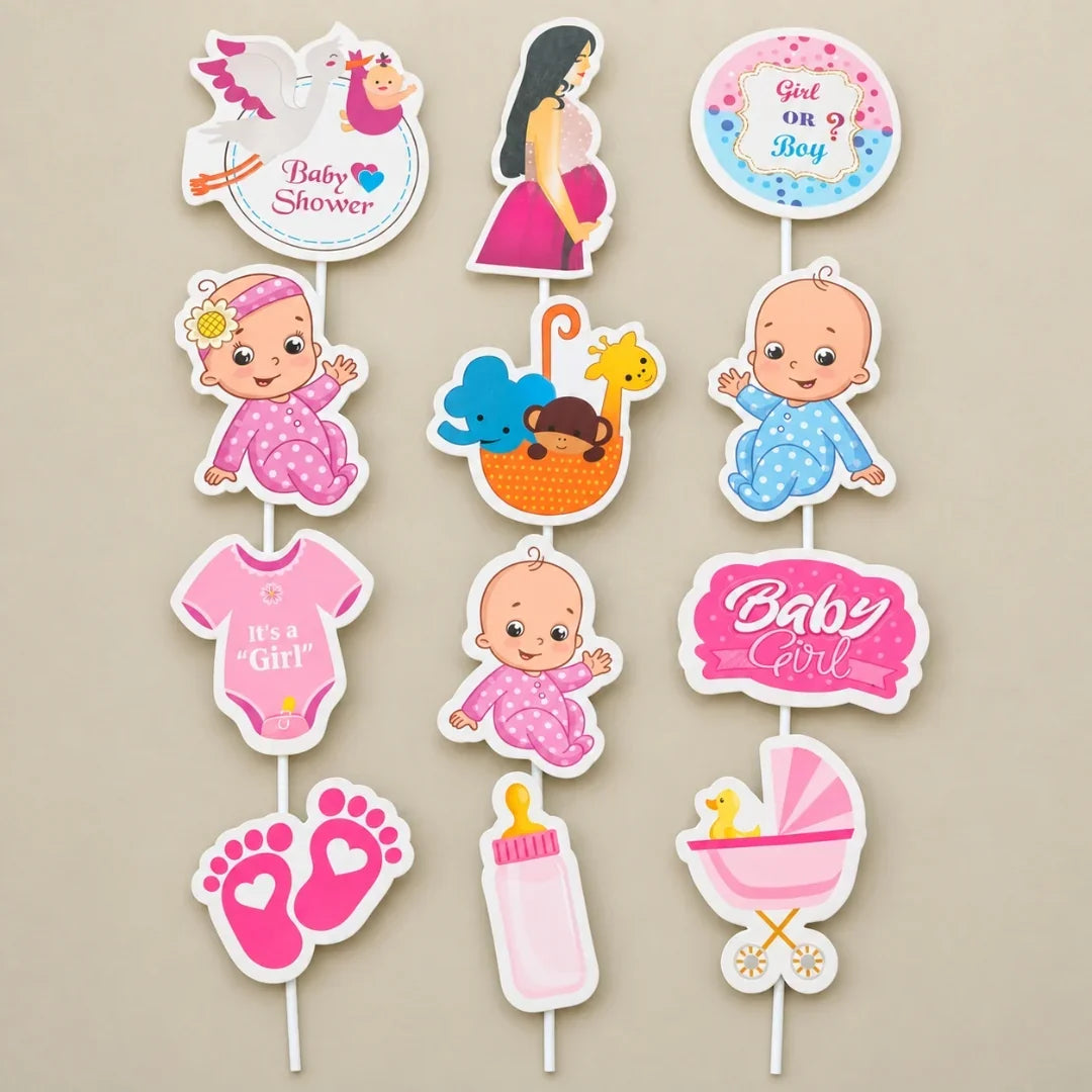 A set of baby shower party decorations on sticks, featuring cartoon illustrations of babies, a baby carriage, a bottle, a swan, and text like 'Baby Shower' and 'Girl or Boy' on a beige background.