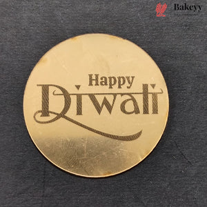 A round gold-colored metal plate engraved with 'Happy Diwali' in dark lettering, displayed on a dark textured background. A 'Bakeyy' brand logo is visible in the top right corner.