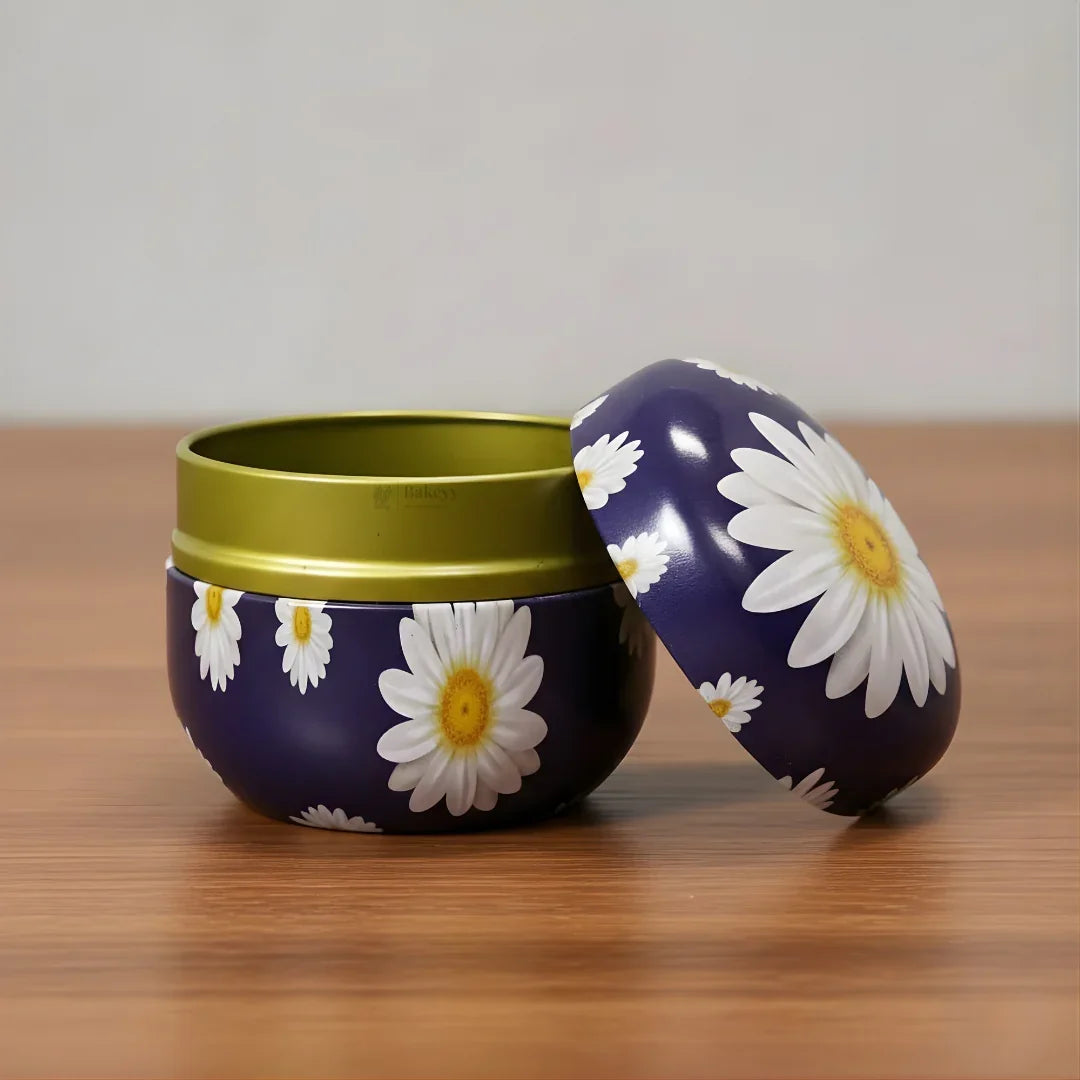 Purple round metal tin with white daisy flowers, lid open, on wooden table, Bakeyy gift packaging