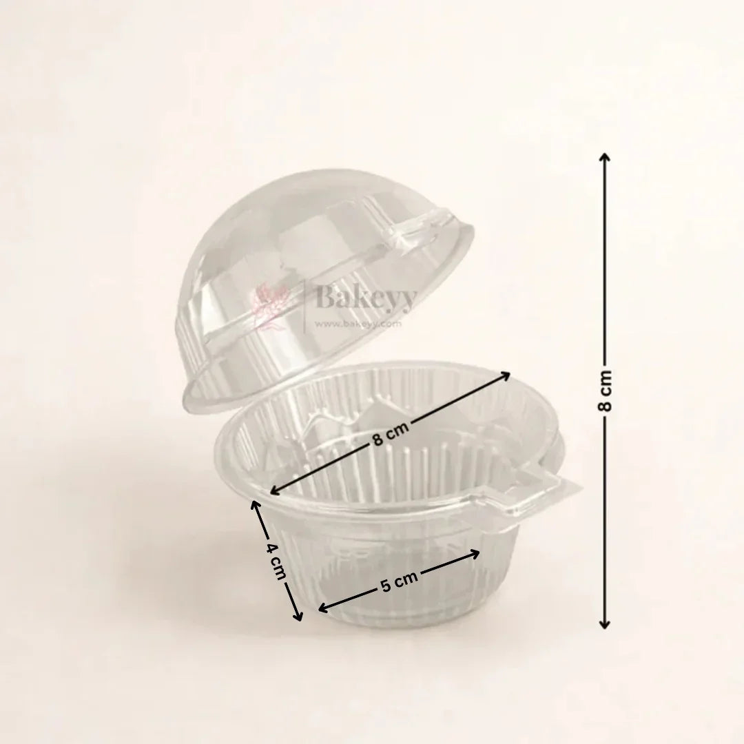 A clear plastic bakery cupcake container with its lid partially open, overlaid with black dimension arrows and labels showing 8 cm height, 8 cm diameter, 4 cm depth, and 5 cm base diameter on a light beige background.