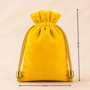 Yellow velvet drawstring pouch with measurements on a beige background