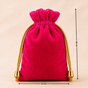 Pink velvet drawstring bag with gold accents and measurements on a beige background
