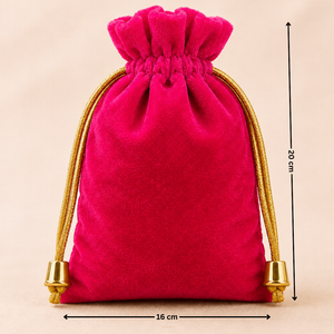 Pink velvet drawstring bag with gold tassels and measurements on a beige background