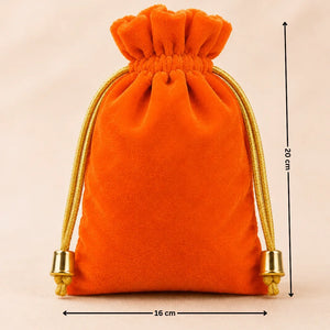 Orange velvet drawstring bag with gold accents on a beige background, showing dimensions.