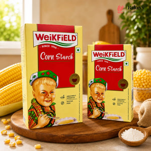 Two boxes of Weikfield Corn Starch on a wooden board with corn kernels and a child illustration.
