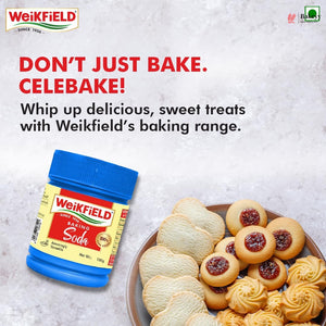 Weikfield baking soda container with cookies on a plate against a light gray background