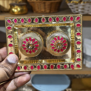 Decorative gold and red rectangular box held by a hand with blurred background