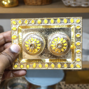 Decorative gold and yellow box held by a hand with a blurred background