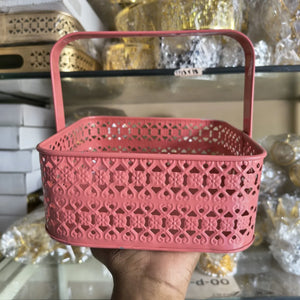 Pink decorative basket held in front of a blurred store shelf.