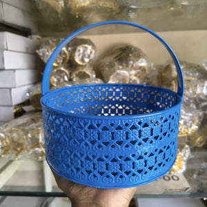 Blue perforated basket held by a hand with a blurred background