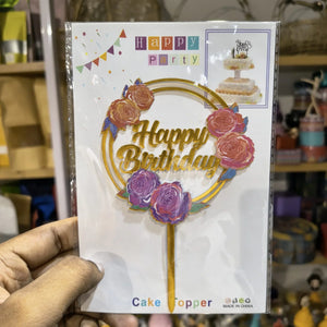 Happy Birthday cake topper packaging held by a hand with a blurred store background