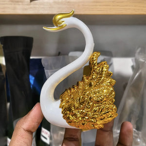 Decorative cake with swan and heart design on a marble surface, featuring the Bakeyy brand.