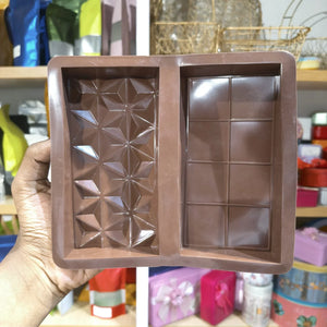 Bronze-colored chocolate mold held by a hand with a blurred background