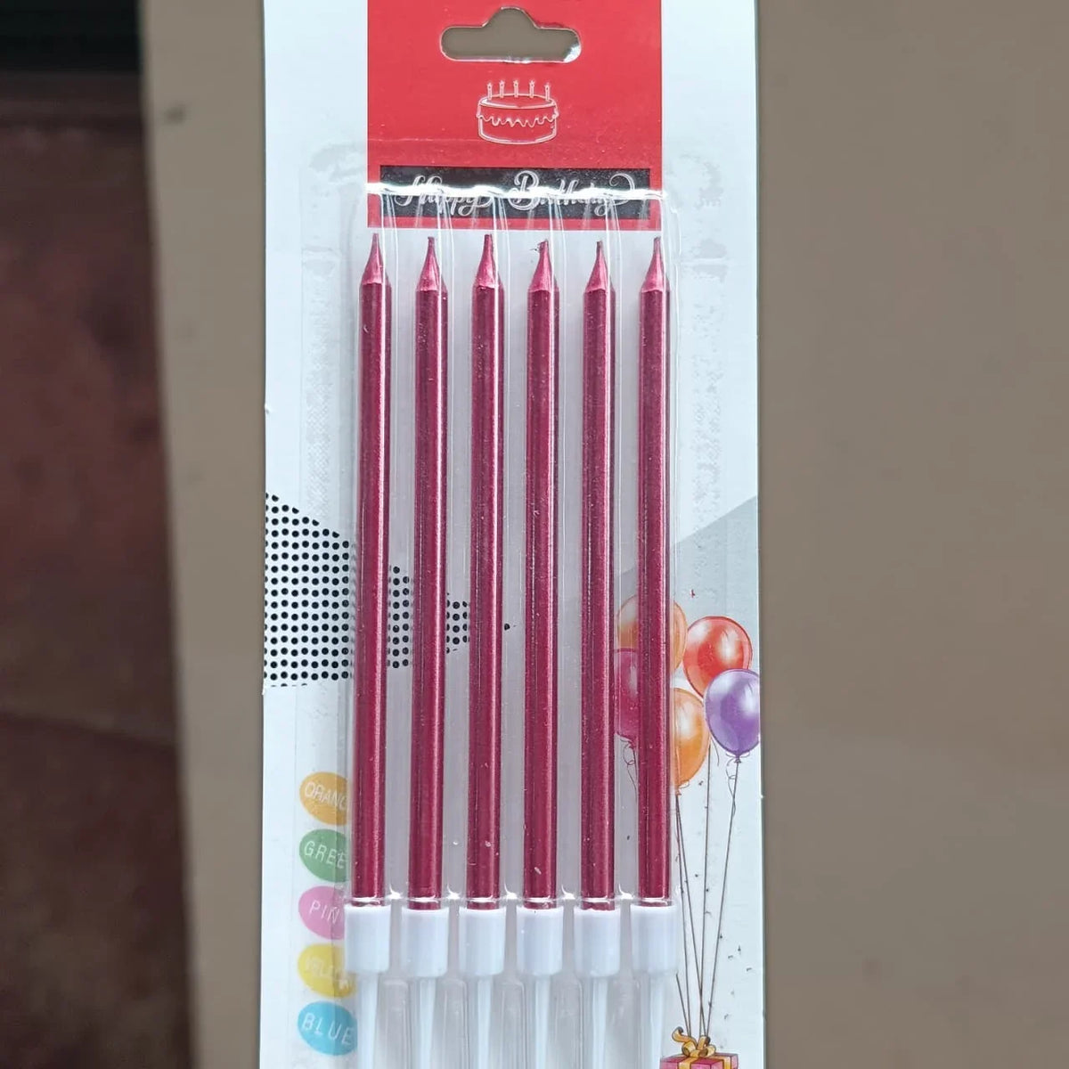 Pack of six birthday candles in a red metallic finish, sealed in a clear plastic sleeve and attached to a white cardboard backing with a red header card.